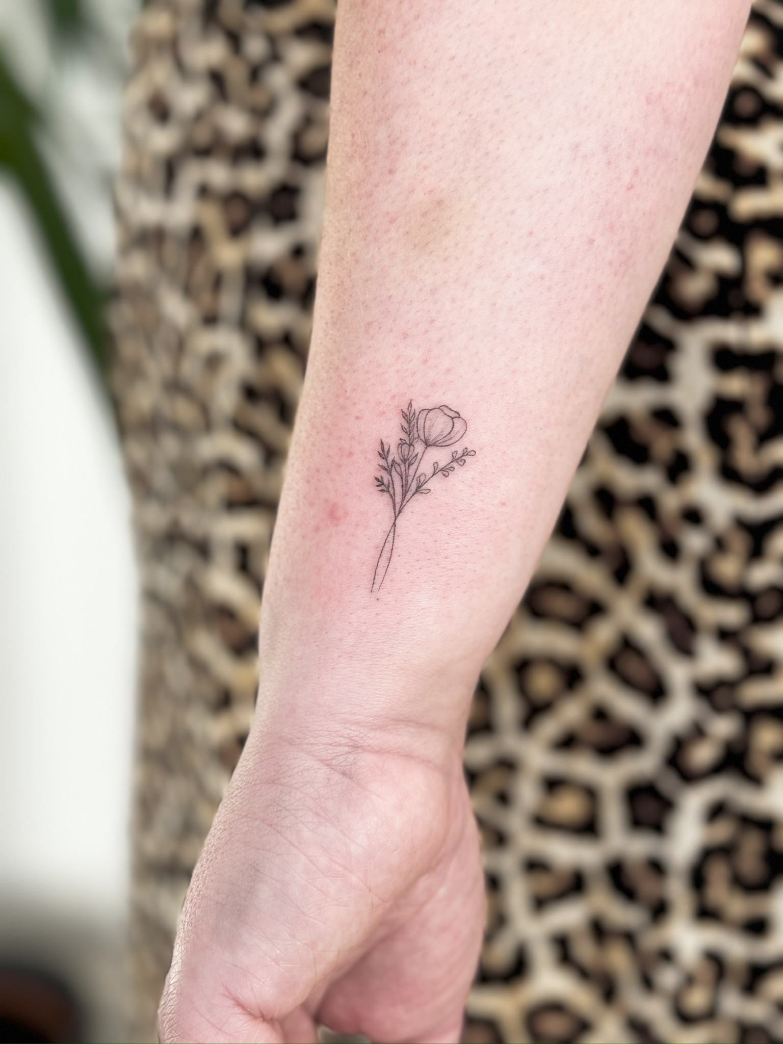 Subtiles Fineline Tattoo mit verspielter Linienführung